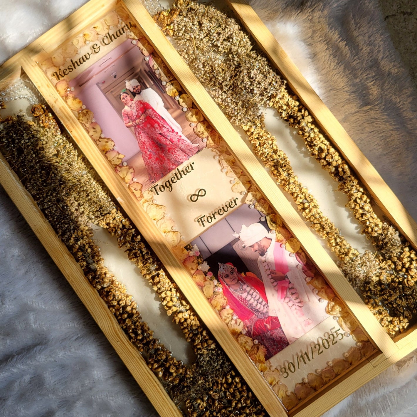Decorative wooden box with gold embellishments and a photo of a couple on a textured surface.